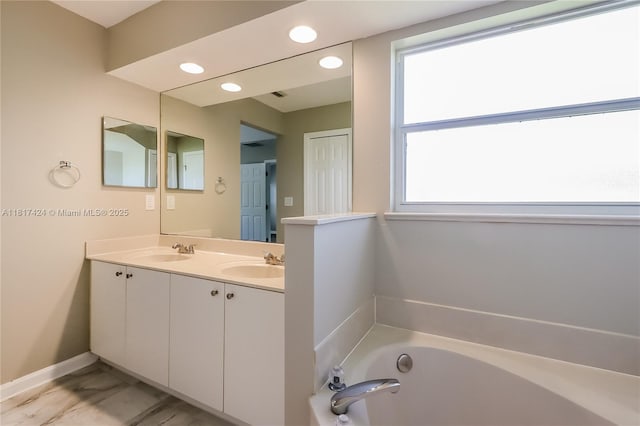 138 SW Bedford Rd, Port St Lucie, FL 34953 - bathroom with double vanity, a garden tub, recessed lighting, and baseboards