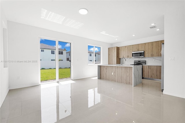 22481 SW 125th Ave Unit A, Miami, FL 33170 - kitchen featuring stainless steel appliances, modern cabinets, brown cabinets, light countertops, and light tile patterned floors