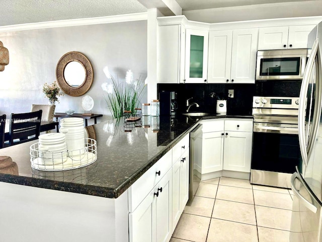 5601 Collins Ave Unit 923, Miami Beach, FL 33140 - kitchen with appliances with stainless steel finishes, a sink, ornamental molding, white cabinets, and a textured ceiling