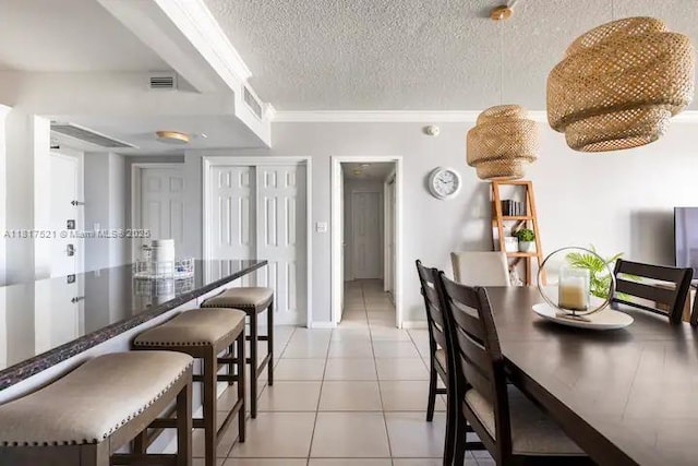 5601 Collins Ave Unit 923, Miami Beach, FL 33140 - dining space with a textured ceiling, light tile patterned flooring, ornamental molding, and baseboards