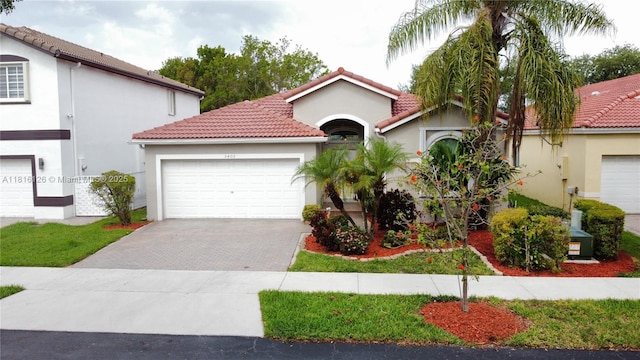 5402 NW 110th Ave, Doral, FL 33178 - mediterranean / spanish-style house with driveway, a garage, stucco siding, and a tile roof