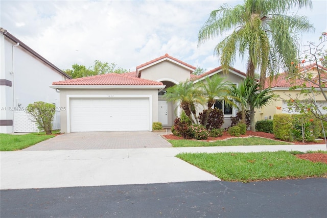 5402 NW 110th Ave, Doral, FL 33178 - mediterranean / spanish-style house featuring driveway, stucco siding, a tiled roof, and an attached garage