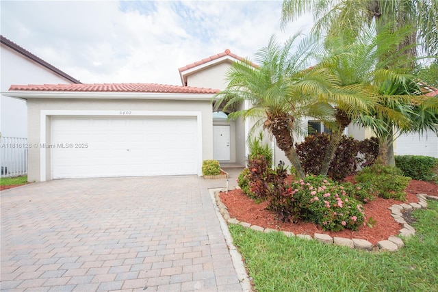 5402 NW 110th Ave, Doral, FL 33178 - mediterranean / spanish-style home featuring decorative driveway, stucco siding, an attached garage, and a tile roof