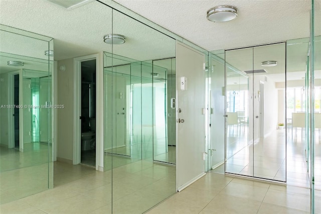 1360 S Ocean Blvd Unit 304, Pompano Beach, FL 33062 - unfurnished room featuring a textured ceiling, light tile patterned floors, elevator, and baseboards