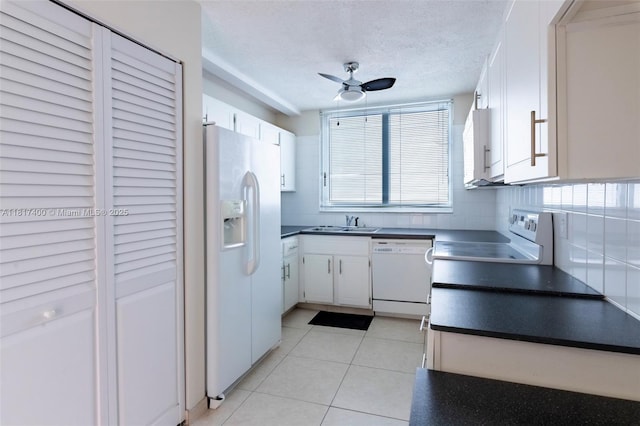1360 S Ocean Blvd Unit 304, Pompano Beach, FL 33062 - kitchen featuring white appliances, dark countertops, ceiling fan, a sink, and white cabinets