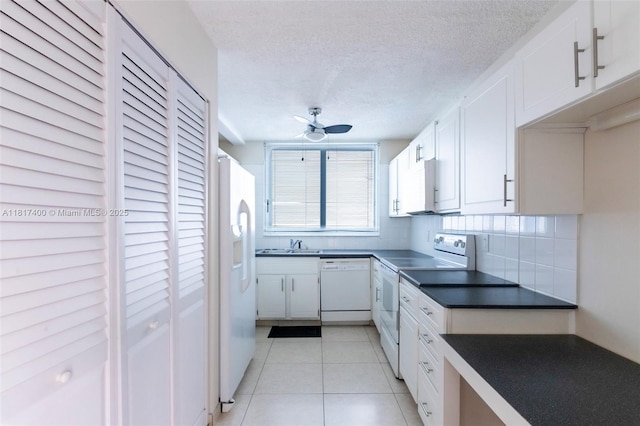1360 S Ocean Blvd Unit 304, Pompano Beach, FL 33062 - kitchen with white appliances, dark countertops, white cabinets, ceiling fan, and a textured ceiling