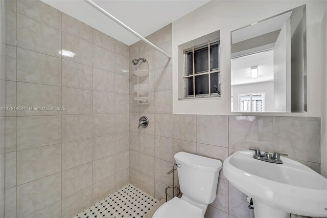 11020 SW 55th St, Miami, FL 33165 - bathroom with a tile shower, toilet, tile walls, and a sink