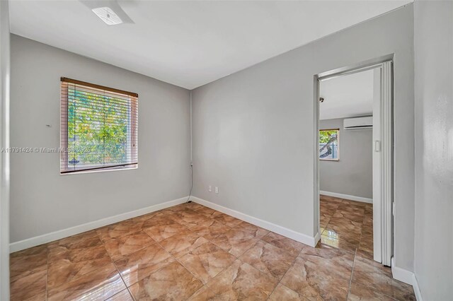 11020 SW 55th St, Miami, FL 33165 - spare room featuring a wall unit AC and baseboards