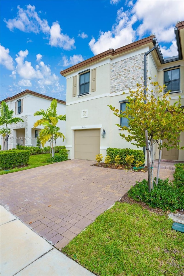 10225 SW 231st Ln, Miami, FL 33190 - view of property featuring decorative driveway, an attached garage, stucco siding, and stone siding