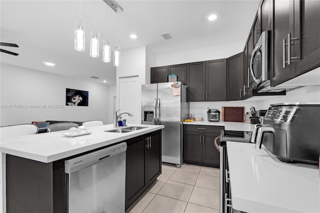 10225 SW 231st Ln, Miami, FL 33190 - kitchen with stainless steel appliances, a sink, a center island with sink, light tile patterned flooring, and decorative light fixtures