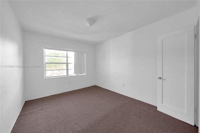 3401 SW 10th St Unit 2B, Miami, FL 33135 - spare room featuring dark carpet and a textured ceiling