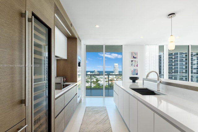 450 Alton Rd Unit 2007, Miami Beach, FL 33139 - kitchen with a sink, light countertops, a view of city, modern cabinets, and a wall of windows