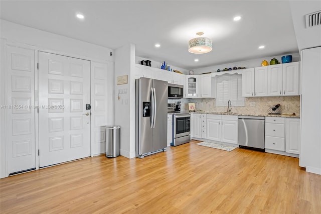 200 Wrenn St Ph 701, Plantation Key, FL 33070 - kitchen with stainless steel appliances, light wood-type flooring, decorative backsplash, white cabinets, and recessed lighting
