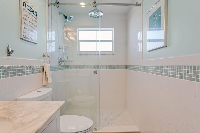 200 Wrenn St Ph 701, Plantation Key, FL 33070 - full bathroom with tile walls, toilet, a stall shower, vanity, and wainscoting