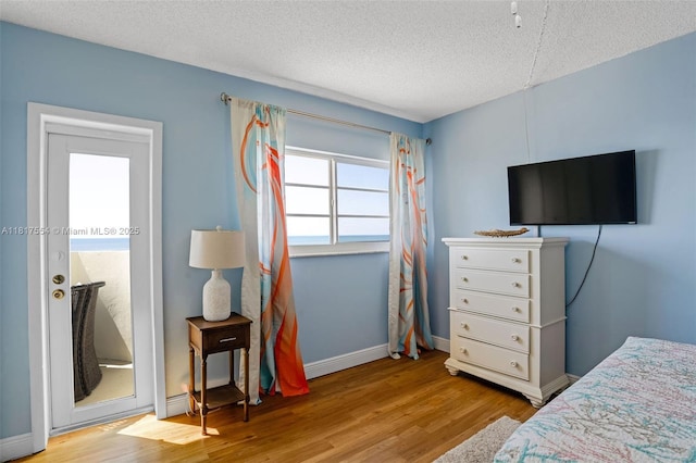 200 Wrenn St Ph 701, Plantation Key, FL 33070 - bedroom featuring wood finished floors, a textured ceiling, and baseboards