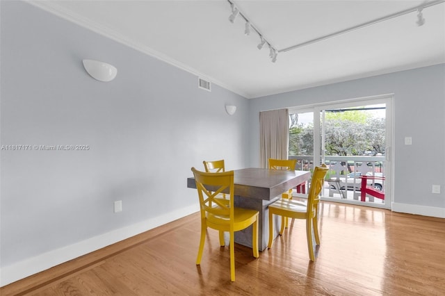 1100 11th St Unit 208, Miami Beach, FL 33139 - dining room featuring track lighting, wood finished floors, baseboards, and crown molding