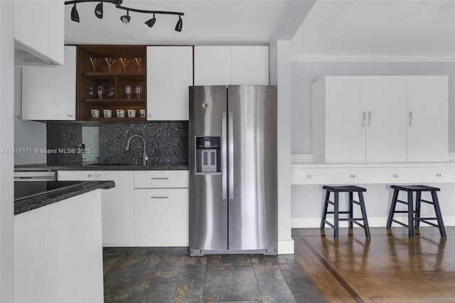 1100 11th St Unit 208, Miami Beach, FL 33139 - kitchen with stainless steel fridge, white cabinetry, open shelves, dark stone counters, and a sink