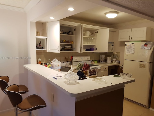 3740 Inverrary Dr Unit 3D, Lauderhill, FL 33319 - kitchen with white appliances, ornamental molding, a peninsula, open shelves, and a kitchen breakfast bar