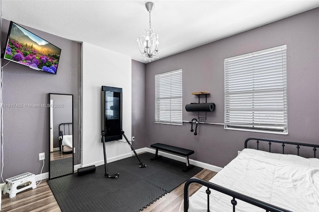 22791 SW 88th Pl, Cutler Bay, FL 33190 - bedroom with a chandelier, wood finished floors, and baseboards