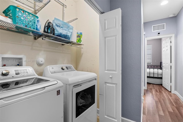 22791 SW 88th Pl, Cutler Bay, FL 33190 - laundry room featuring washing machine and dryer, light wood-style floors, and baseboards