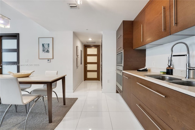 485 Brickell Ave Unit 1801, Miami, FL 33131 - kitchen with stainless steel appliances, light countertops, light tile patterned floors, modern cabinets, and recessed lighting