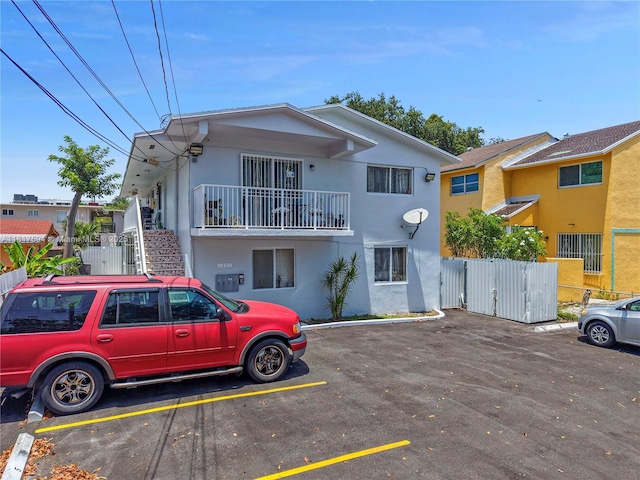 1621 NW 16th St, Miami, FL 33125 - view of property featuring a gate, uncovered parking, stucco siding, and a balcony