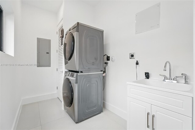 1845 NE 124th St, North Miami, FL 33181 - laundry area with stacked washing machine and dryer, electric panel, baseboards, and light tile patterned floors