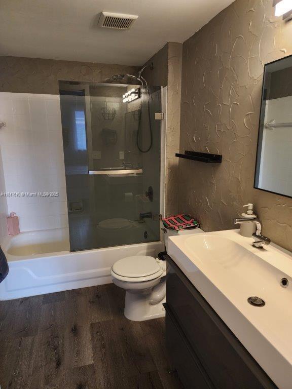 460 S Park Rd Unit 6-209, Hollywood, FL 33021 - full bathroom featuring vanity, wood finished floors, toilet, bathing tub / shower combination, and a textured wall