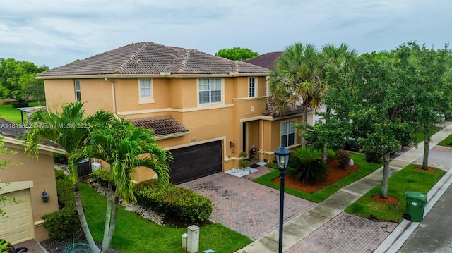 4452 Rainbow Ave, Weston, FL 33332 - view of front of home with decorative driveway, an attached garage, a tile roof, and stucco siding