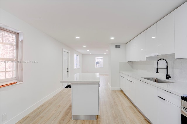6044 SW 37th St, Miramar, FL 33023 - kitchen featuring a sink, modern cabinets, a center island, white cabinets, and light wood finished floors