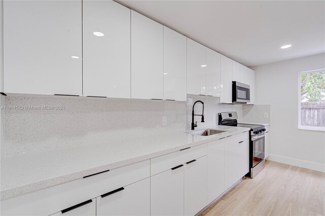 6044 SW 37th St, Miramar, FL 33023 - kitchen with appliances with stainless steel finishes, a sink, modern cabinets, white cabinets, and recessed lighting