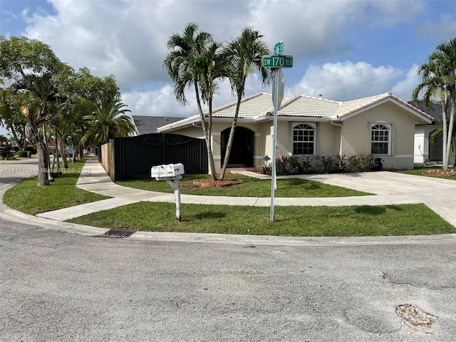 14610 SW 170th Ter, Miami, FL 33177 - ranch-style house with a tile roof, a front lawn, stucco siding, and concrete driveway