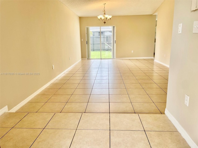 14610 SW 170th Ter, Miami, FL 33177 - unfurnished room featuring light tile patterned floors, a chandelier, a textured ceiling, and baseboards