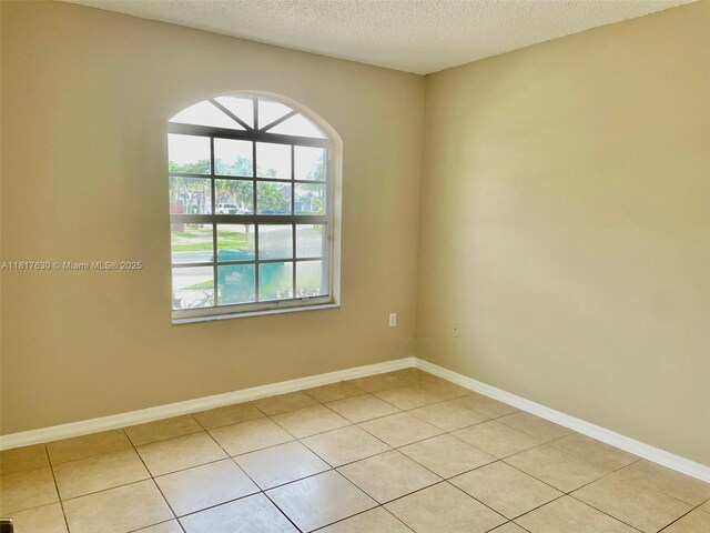 14610 SW 170th Ter, Miami, FL 33177 - unfurnished room featuring a textured ceiling, light tile patterned floors, and baseboards