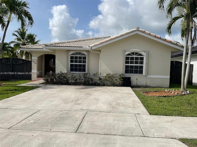 14610 SW 170th Ter, Miami, FL 33177 - view of front of house with a tile roof, stucco siding, and a front lawn