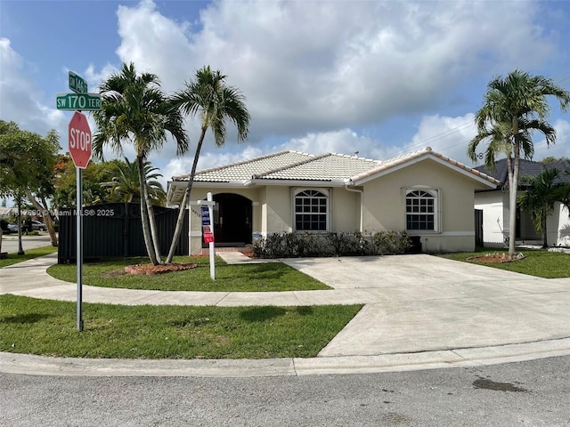 14610 SW 170th Ter, Miami, FL 33177 - view of front facade with a tiled roof, stucco siding, and a front lawn