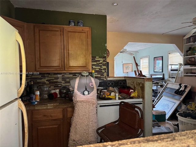 1134 NE 5th Ter, Fort Lauderdale, FL 33304 - kitchen with freestanding refrigerator, ceiling fan, backsplash, and brown cabinetry