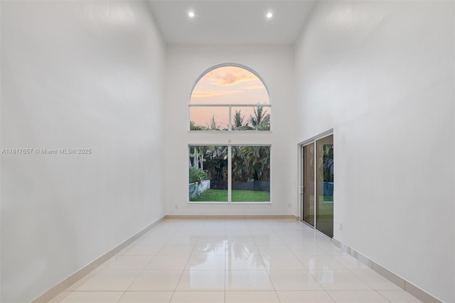 4425 NW 93rd Doral Ct, Doral, FL 33178 - spare room featuring healthy amount of natural light, light tile patterned flooring, recessed lighting, a high ceiling, and baseboards