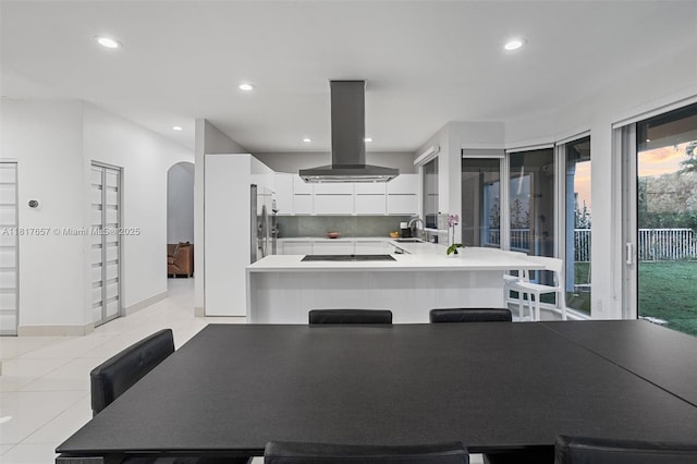 4425 NW 93rd Doral Ct, Doral, FL 33178 - kitchen featuring island exhaust hood, white cabinets, light countertops, a peninsula, and recessed lighting