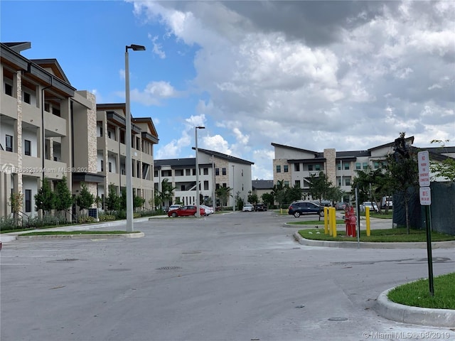 8055 NW 104th Ave Unit 32, Doral, FL 33178 - view of asphalt road with curbs, street lights, and traffic signs