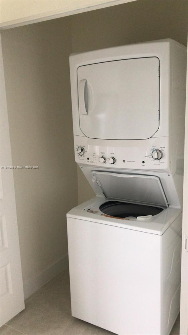 8055 NW 104th Ave Unit 32, Doral, FL 33178 - laundry area with stacked washing machine and dryer, baseboards, and light tile patterned flooring