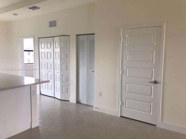 8055 NW 104th Ave Unit 32, Doral, FL 33178 - unfurnished bedroom with multiple closets, baseboards, and tile patterned flooring