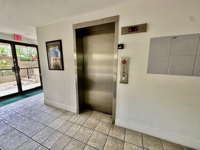 110 Salamanca Ave Unit 207, Coral Gables, FL 33134 - corridor featuring elevator, light tile patterned floors, and french doors