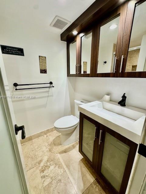 110 Salamanca Ave Unit 207, Coral Gables, FL 33134 - bathroom featuring vanity, toilet, and baseboards