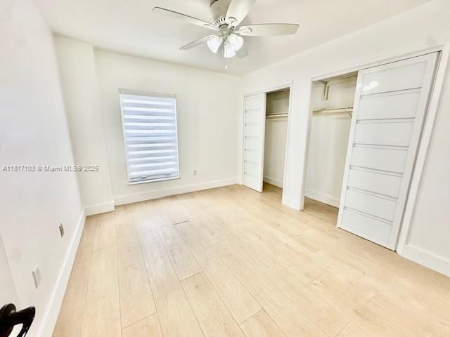110 Salamanca Ave Unit 207, Coral Gables, FL 33134 - unfurnished bedroom with two closets, light wood-style flooring, baseboards, and ceiling fan