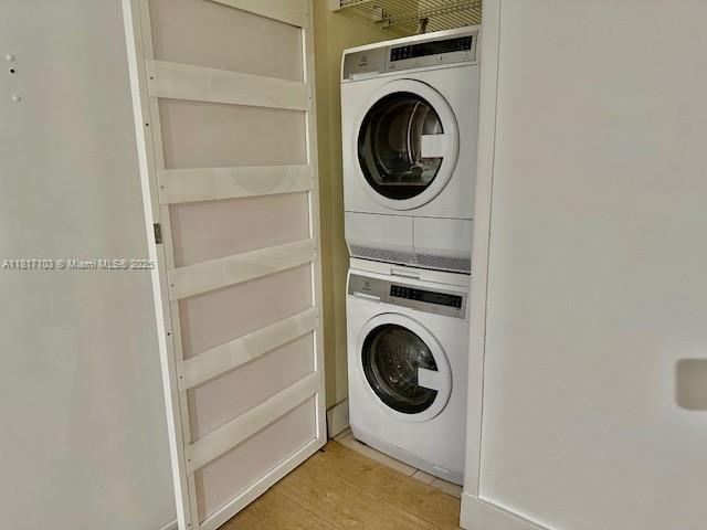 110 Salamanca Ave Unit 207, Coral Gables, FL 33134 - laundry area featuring stacked washer / drying machine and light wood-type flooring