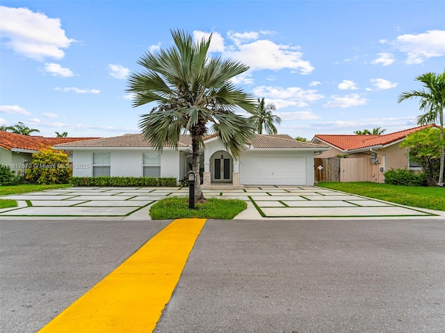 5976 SW 88th Pl, Miami, FL 33173 - view of front facade featuring stucco siding, concrete driveway, an attached garage, and a tiled roof