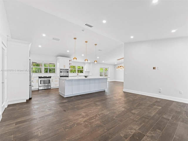 5976 SW 88th Pl, Miami, FL 33173 - kitchen with appliances with stainless steel finishes, a kitchen island, plenty of natural light, dark wood-style flooring, and recessed lighting