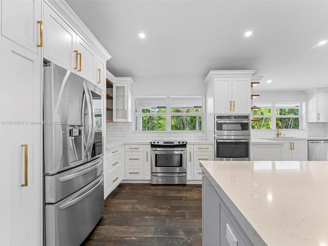 5976 SW 88th Pl, Miami, FL 33173 - kitchen featuring stainless steel appliances, dark wood-style floors, backsplash, recessed lighting, and white cabinets