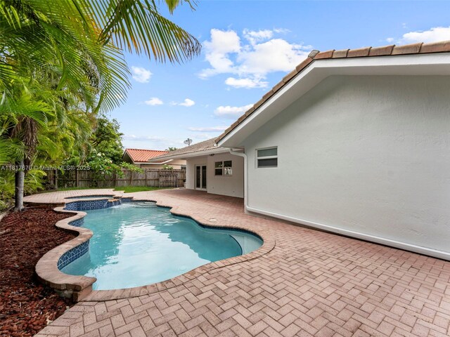 5976 SW 88th Pl, Miami, FL 33173 - view of pool with a patio, a fenced backyard, and a pool with connected hot tub